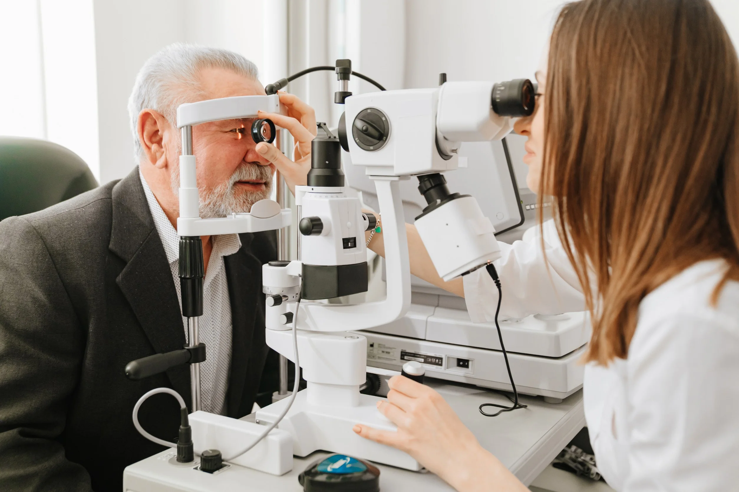 Eye care professional examining a patient with a slit lamp microscope